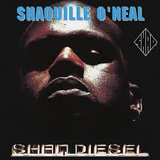 Shaquille O'Neal's face in a dark setting, looking down at the viewer.